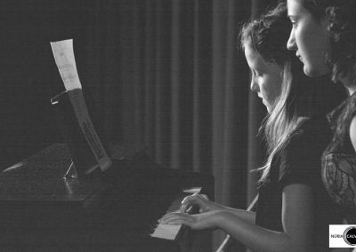 Niña tocando el piano en concierto