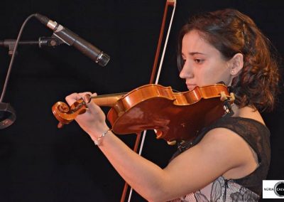 Chica tocando violín en concierto