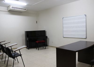 Aula de Classes amb pissarra, bancs i piano