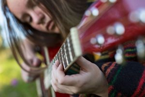 Primer plano de chica tocando la guitarra clásica
