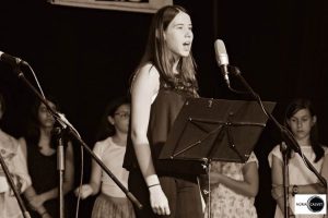 Joven cantando sobre escenario