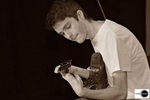 Joven tocando la guitarra en concierto