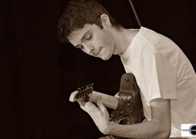 Joven tocando la guitarra en concierto