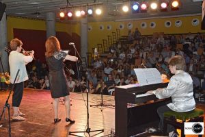 profesora y alumna tocando el violín y chico tocando el piano