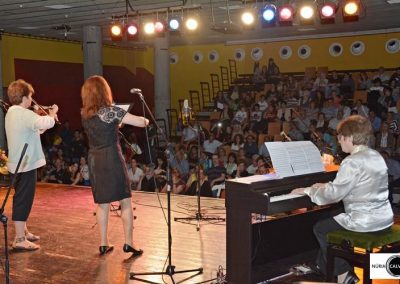 profesora y alumna tocando el violín y chico tocando el piano