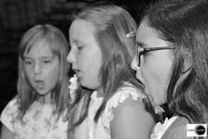 Tres niñas cantando en concierto