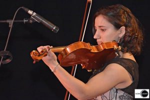 Chica tocando violín en concierto