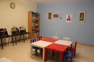 Aula infantil con mesas y bancos de diferentes colores