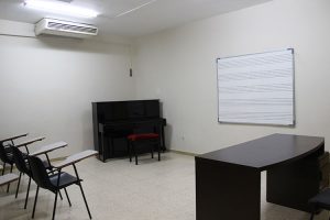 Aula de Clases con pizarra, bancos y piano