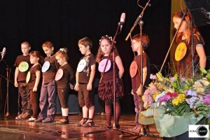 Niños sobre escenario en espectáculo musical