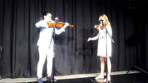 Dos niñas sobre el escenario tocando el violín
