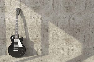 Guitarra apoyada sobre una pared