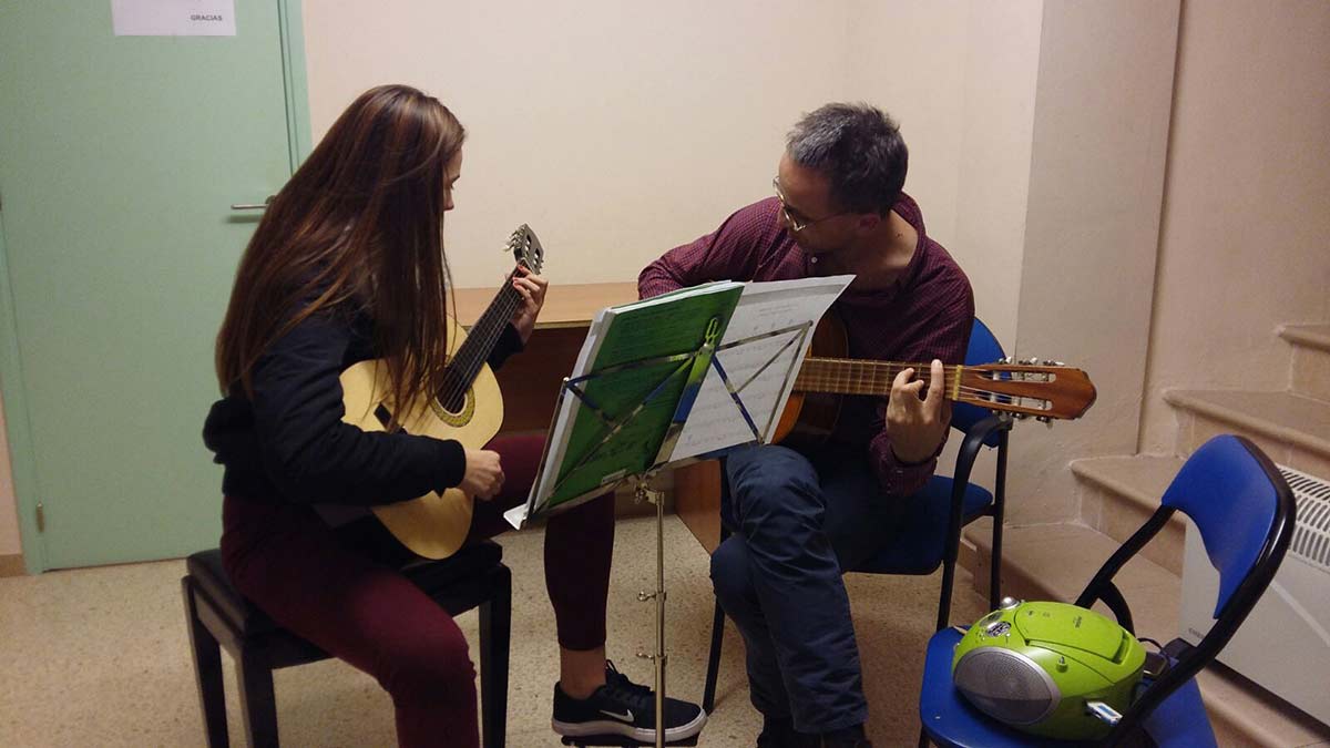 Clases de Guitarra Escuela de Música EMAR Barcelona Alumna y profesor en Clases de Guitarra