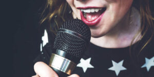 Mujer joven cantando con micrófono